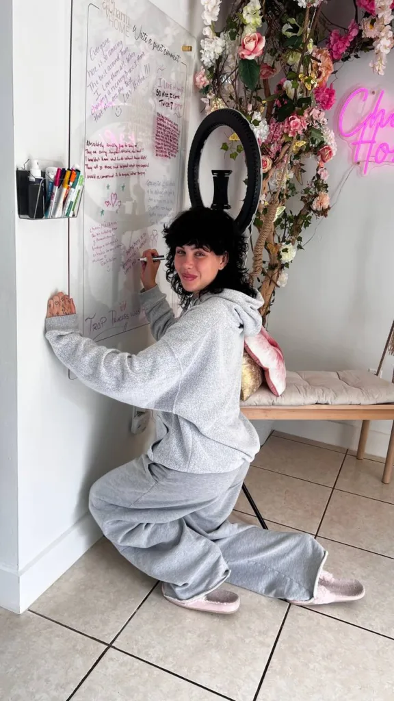 Cliente recuperándose en Charm Home Miami, escribiendo en el mural de mensajes motivacionales